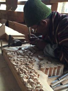 Man curving wood, traditional way of woodcurving in Bhutan